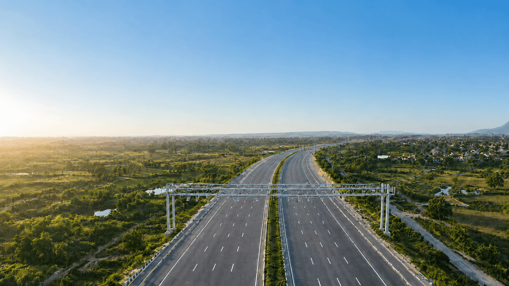 Aerial view of a Margdarshak toll plaza on an open highway at golden hour